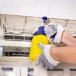technician-spraying-chemical-water-onto-air-condit-PPEB8PH.jpg